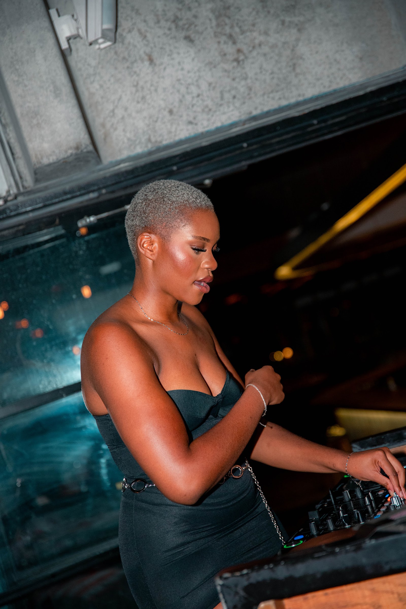 A DJ adjusting the mixer, lit from the side